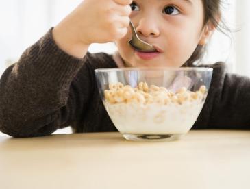 Girl eating cereal from bowl